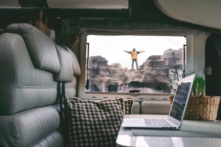 digital nomad standing outside his compact travel trailer similar to van life